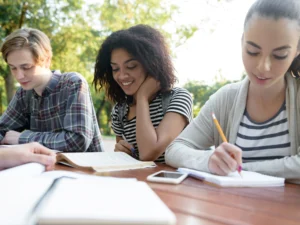 happy_young_people_friends_sitting_studying_outdoors_1.webp